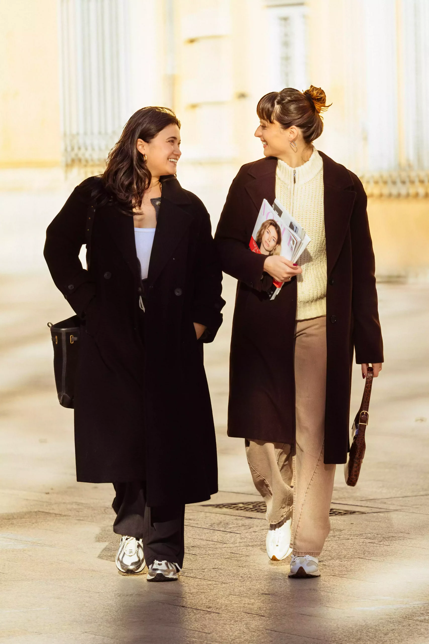 Deux femmes marchent ensemble, élégantes.